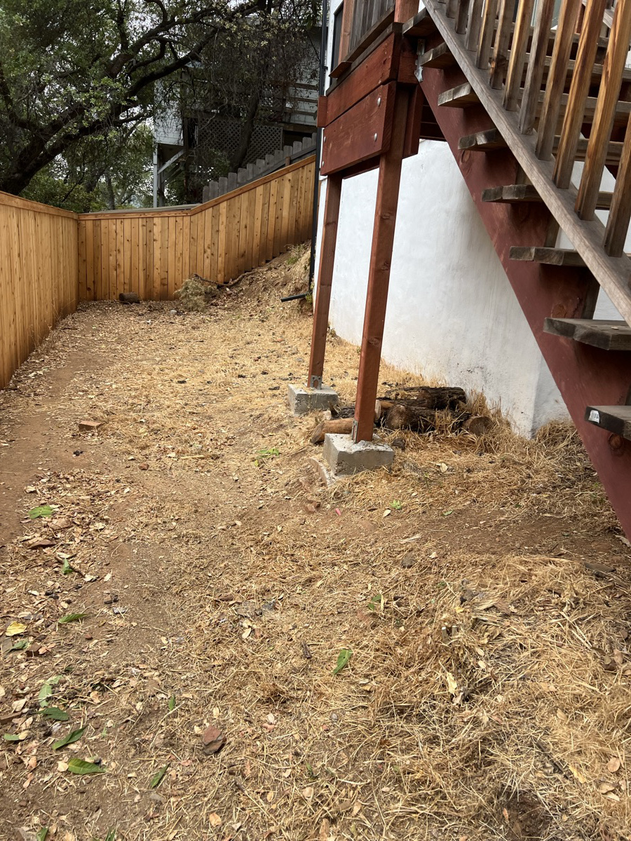 Brush clearing on a hillside near a deck for wildfire safety