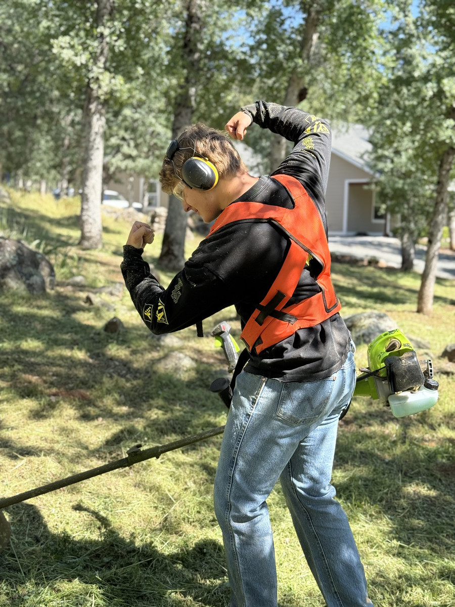 Crew member flexing with weed eater