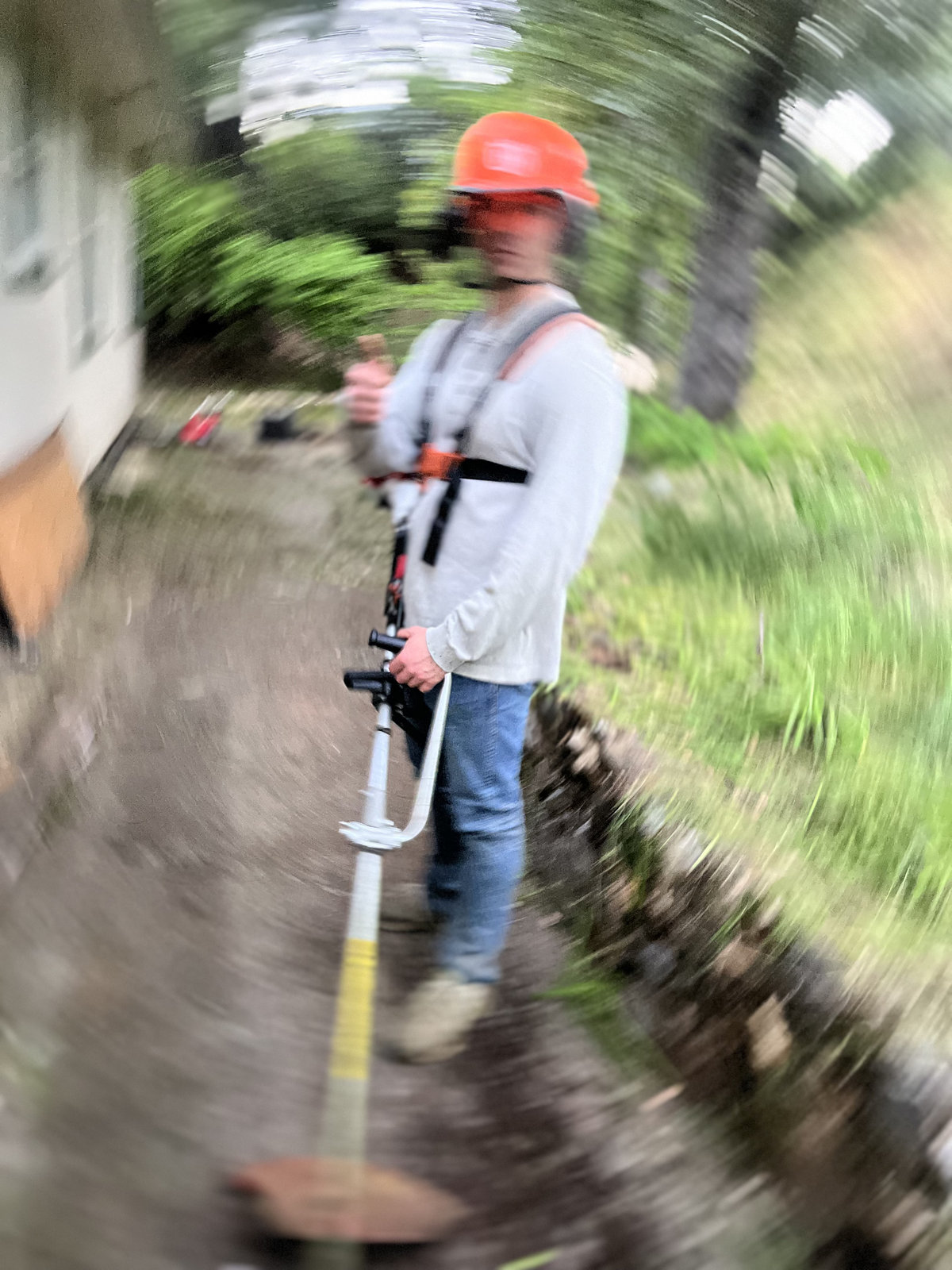 Crew member weed eating in action motion shot