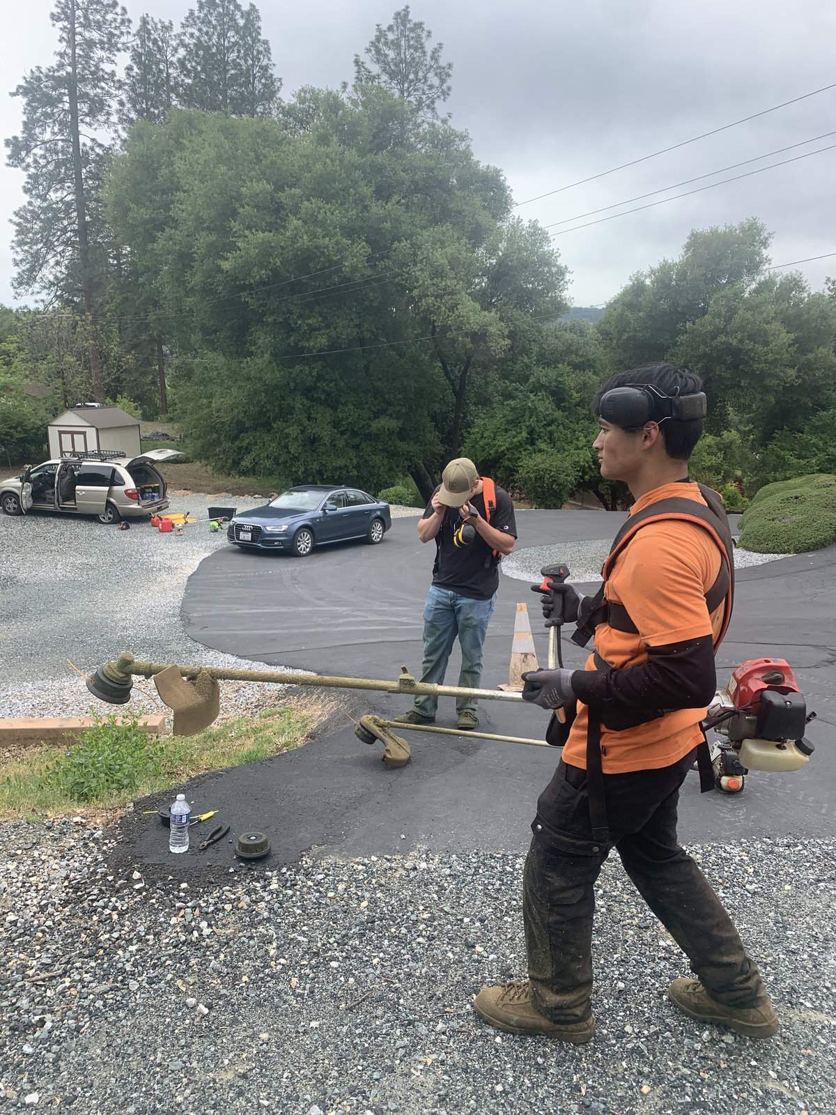 Crew members gearing up with weed eaters at job site