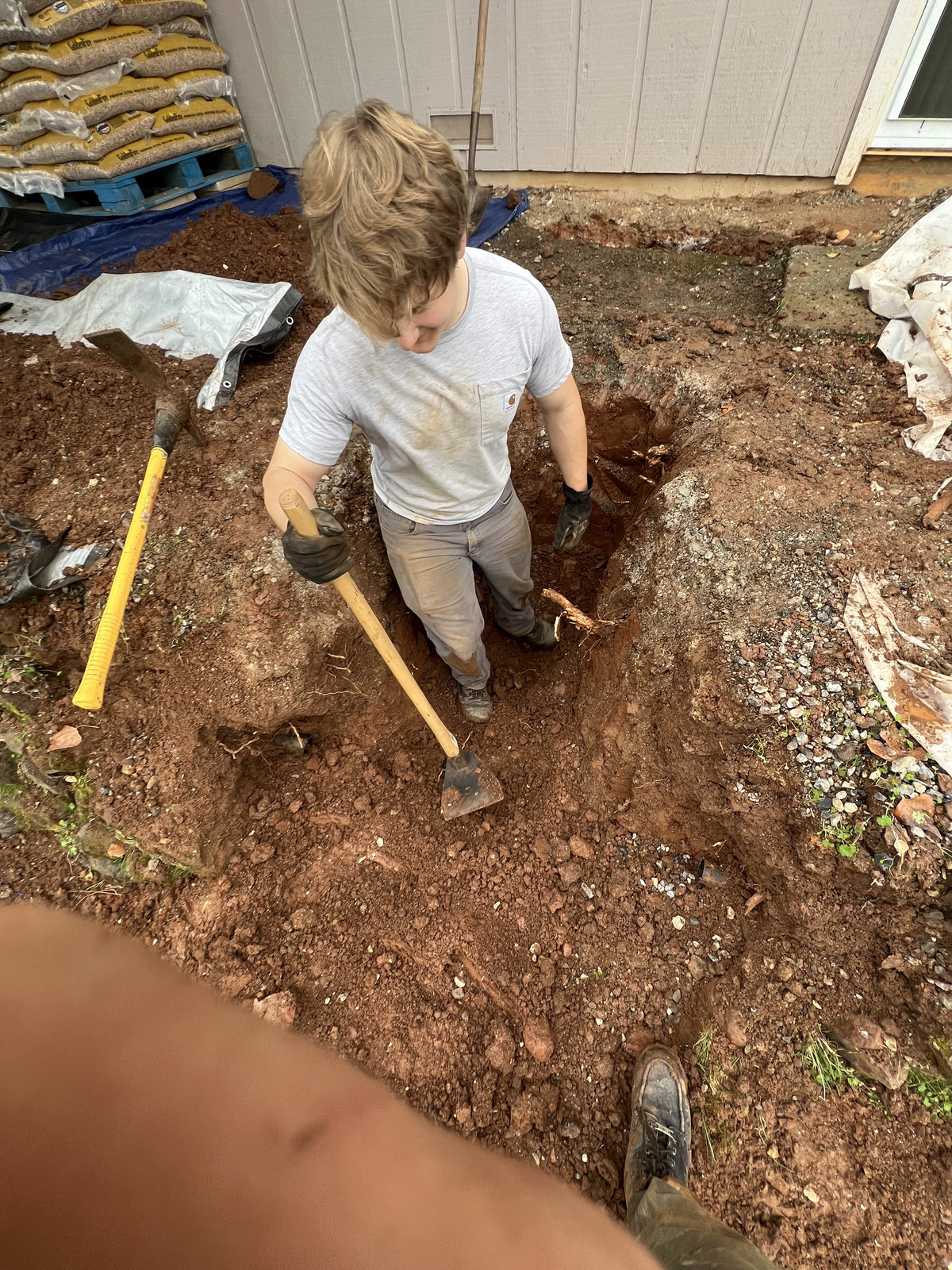 Crew member digging for a landscaping project