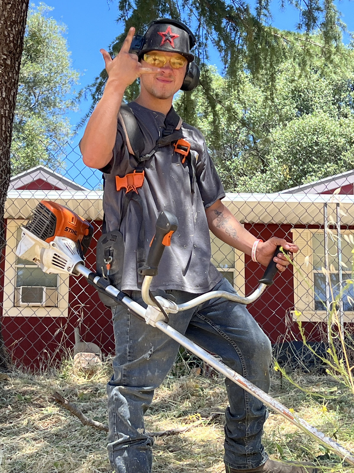 Crew member having fun with weed eater on the job