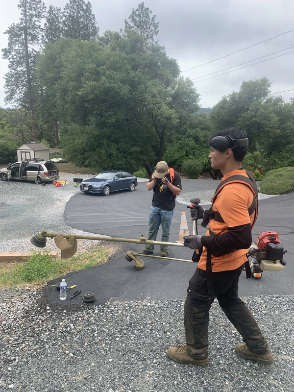 Crew members gearing up with weed eaters at the job site