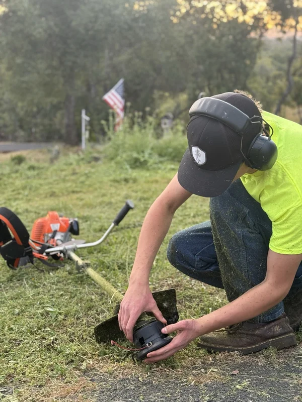 Wacky Weedeating crew member gearing up a weed eater